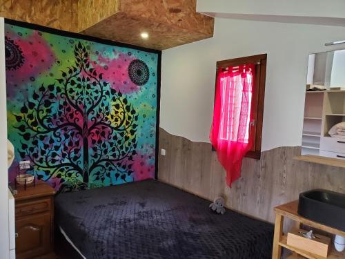 Schlafzimmer mit einem Bett mit Wandgemälde in der Unterkunft Mon cocon in Xonrupt-Longemer