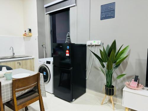 a black refrigerator in a kitchen with a washing machine at CoreSoho Suite by BKAstaycation KotaWarisan Sepang KLIA Airport, Free Wifi in Sepang