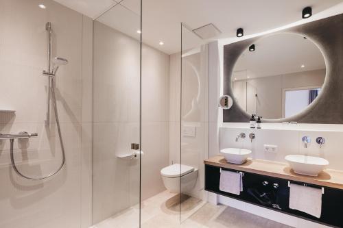 a bathroom with a shower and a toilet and a sink at Landhotel Voshövel in Schermbeck