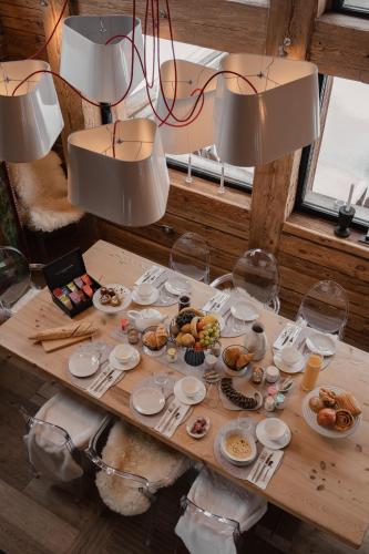 un tavolo di legno con piatti di cibo sopra di Chalet Papillon - LES CHALETS COVAREL a Val dʼIsère