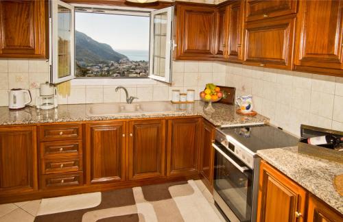 a kitchen with wooden cabinets and a sink and a window at Eirini's home in Kalymnos
