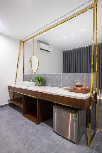 a bathroom with a tub and a sink and a mirror at Clover Home Quảng Bình in Dong Hoi
