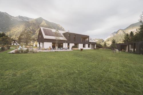 una casa en un campo con montañas en el fondo en The Campus Alps - tiny homes, en Hieflau