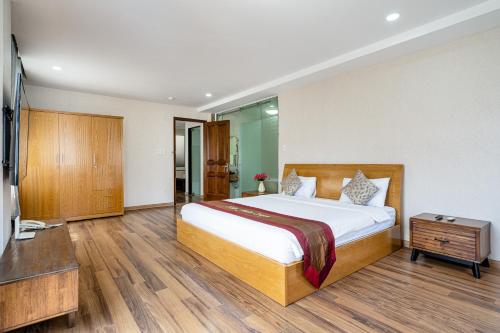 a bedroom with a large bed and a television at La Palma - Garden Saigon Hotel Phu My Hung in Ho Chi Minh City