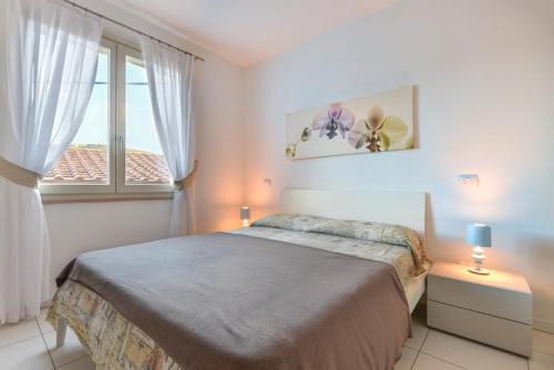 1 dormitorio con cama y ventana grande en Mimì, en Capoliveri