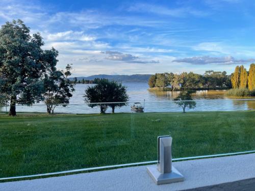 a view of a lake with a bench in the grass at Horizons 424 Lake Jindabyne Waterfront 2 Bedroom Apartment in Jindabyne