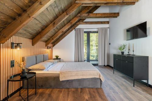 1 dormitorio con cama grande y techo de madera en Luxury House Masuria, en Jabłonka