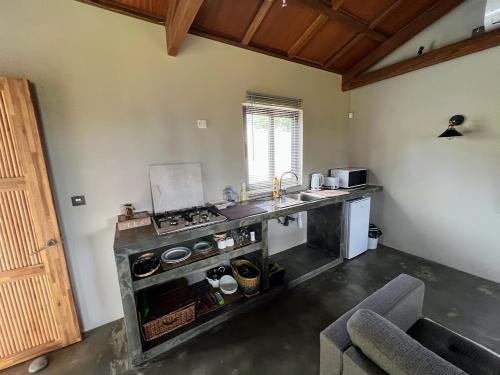 a kitchen with a stove and a counter top at Lakaz Kannell - Vanilla Lodge, secluded outside bath & shower infinity pool in Cap Malheureux