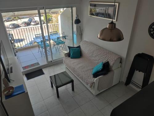 d'un salon avec un canapé et une table ainsi que d'un balcon. dans l'établissement Studio avec Mezzanine classé 3 etoiles en bord de Mer, à Saint-Cyprien