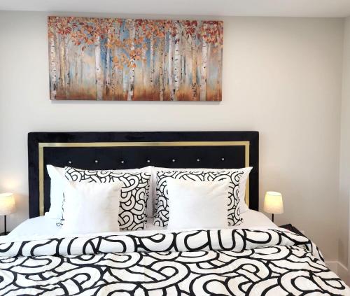 a bedroom with a bed with a painting on the wall at Cozy King Suite in the heart of Towson in Towson