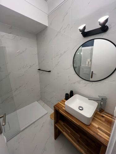 une salle de bain blanche avec un lavabo et un miroir dans l'établissement Studio centre-ville Beaulieu-sur-Mer, à Beaulieu-sur-Mer