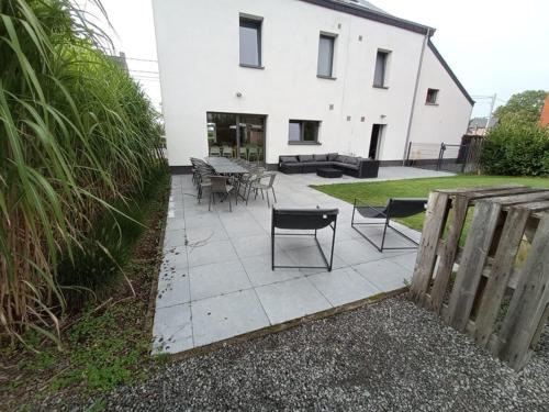 a patio with tables and chairs in front of a building at Gîte du Lac in Fosses-La-Ville