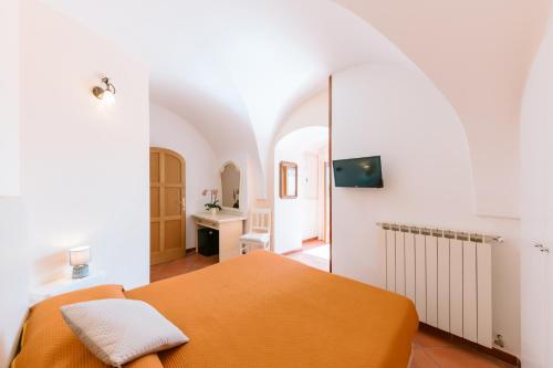 ein Schlafzimmer mit einem orangenen Bett und einem Spiegel in der Unterkunft Albergo La Margherita in Scala