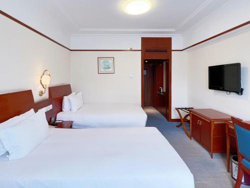 Postel nebo postele na pokoji v ubytování Hangzhou Xinqiao Hotel
