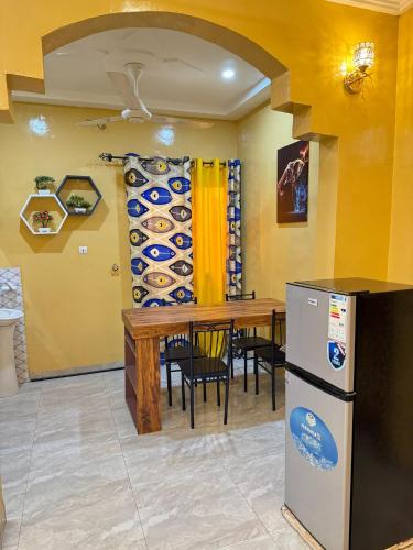 uma sala de jantar com uma mesa e um frigorífico em FS service em Ouagadougou