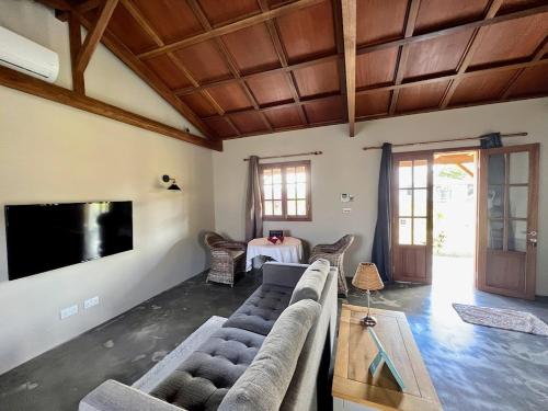 a living room with a couch and a flat screen tv at Lakaz Kannell - Room 2 - Turtle Lodge, secluded outside bath & shower infinity pool in Cap Malheureux
