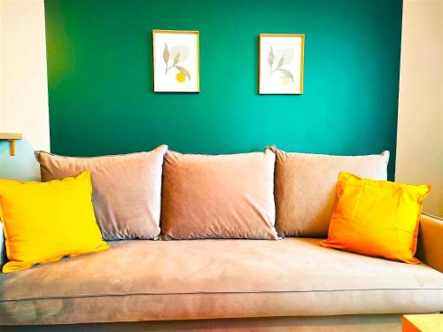 a couch with colorful pillows in a living room at SECOND HOME Lubawa - 3 pokoje, 5 łóżek, Netflix i Max, parking, winda in Lubawa