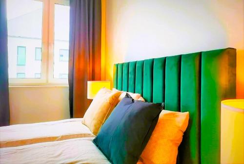 a bedroom with a bed with a green headboard at SECOND HOME Lubawa - 3 pokoje, 5 łóżek, Netflix i Max, parking, winda in Lubawa