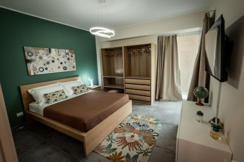 Un dormitorio con una cama y una pared verde. en King's house apartments, en Palermo