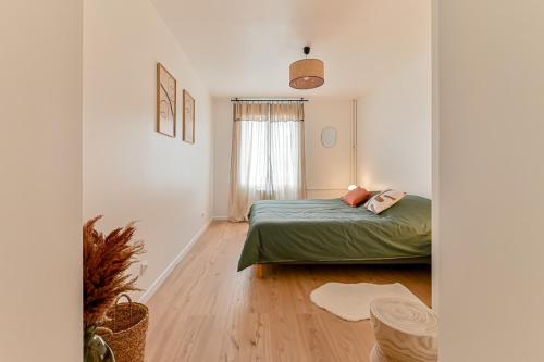 1 dormitorio con cama y ventana en Appartement cosy proche de Paris, en Bagnolet