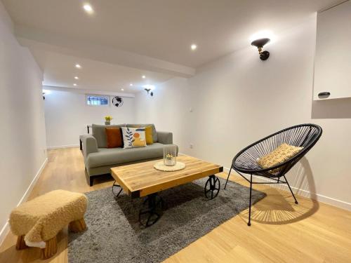 a living room with a couch and a table and a chair at TEA&CHILL - Manhattan home - proche gare in Tremblay En France
