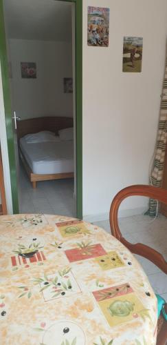 une table avec un tissu de table et un lit dans l'établissement Petite maison en Ardèche, à Saint-Martin-dʼArdèche