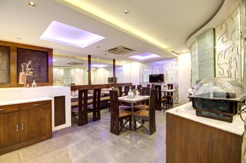 a kitchen with a bar and a dining room at Hotel Good Times Near Metro in New Delhi