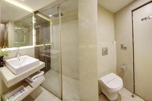 y baño con lavabo, aseo y ducha. en Hotel Good Times Near Metro, en Nueva Delhi
