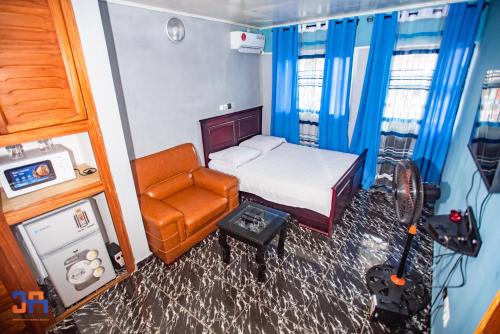 a bedroom with a bed and a chair and a camera at CAMERHOME "Low Cost" in Douala