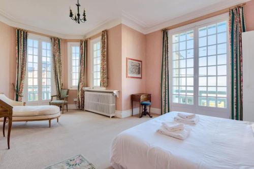 une chambre avec un grand lit blanc et des fenêtres dans l'établissement Villa La Petite Normandy Vue Mer, à Trouville-sur-Mer