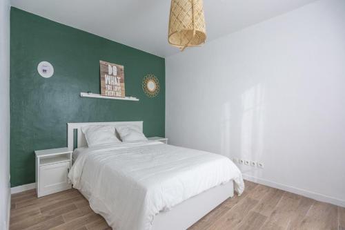 1 dormitorio con cama blanca y pared verde en Tea&Chill - Mimosa - Proche métro 5, en Drancy