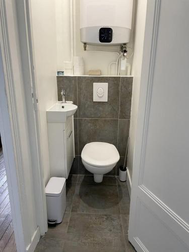 a small bathroom with a toilet and a sink at TEA&CHILL T2 La tête dans les nuages - Proche gare in Aulnay-sous-Bois