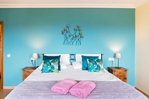 a blue bedroom with a bed with two pink towels at Casa Roble B&B in Cómpeta