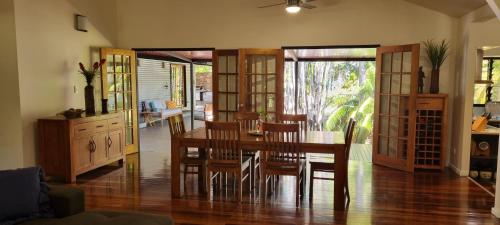 a dining room with a wooden table and chairs at Berry Springs Tropical Retreat in Berry Springs