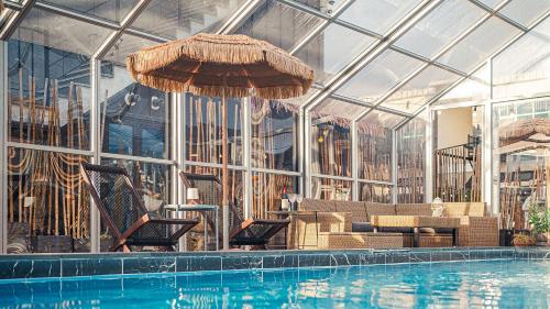a pool with chairs and umbrellas in a building at Majoong Pool Villa Pension in Gyeongju