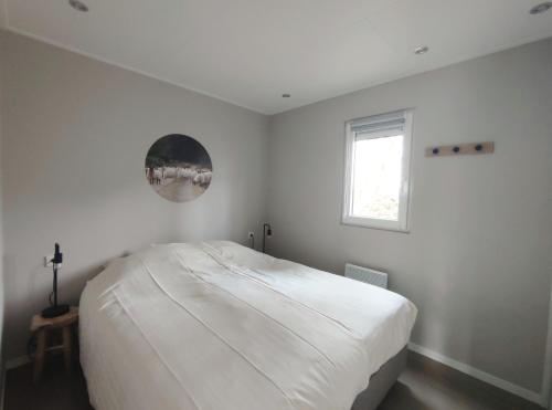 een witte slaapkamer met een groot bed. bij Natuurhuisje Hellendoorn in Haarle