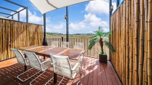 a patio with a table and chairs on a deck at Majoong Pool Villa Pension in Gyeongju