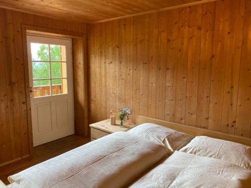 a bedroom with a bed and a window and a door at Farmhouse with a stunning view over the dolomites in Villnoss