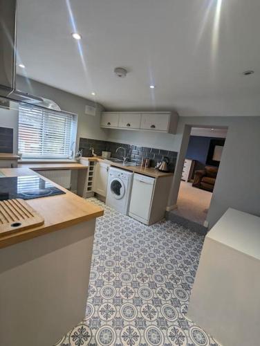 a kitchen with a washer and dryer in it at Blue Bell Apartment in Kidsgrove