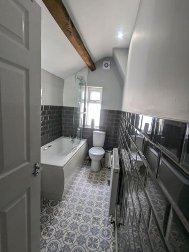 La salle de bains est pourvue d'une baignoire, de toilettes et d'un lavabo. dans l'établissement Blue Bell Apartment, à Kidsgrove