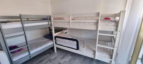 une chambre avec trois lits superposés dans une pièce dans l'établissement Juan-Les-Pins 150m des plages 6 couchages Parking, à Juan-les-Pins