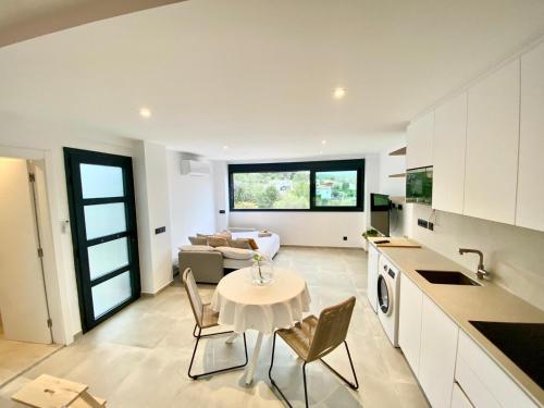 a kitchen and living room with a table and chairs at Pandi's Place in Sant Pere de Ribes