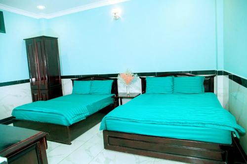 2 letti in una camera con pareti blu di Mi Linh Hotel a Nha Trang