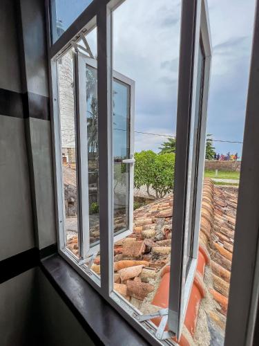 a window looking out at a brick wall at Light House View Inn - Galle Fort in Galle