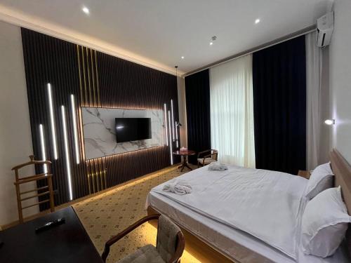 1 dormitorio con 1 cama y TV de pantalla plana en Mixt Royal Palace, en Samarkand