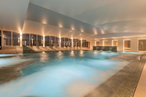 a large swimming pool in a building with lights at PALASIET Wellness Clinic&Thalasso 4 SUP in Benicàssim