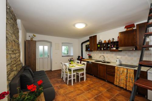 uma cozinha e sala de estar com uma mesa e um sofá em Barbara`s Village House em Ilirska Bistrica