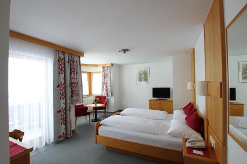 pokój hotelowy z łóżkiem i telewizorem w obiekcie Hotel Garni Bel-Ami w mieście Galtür