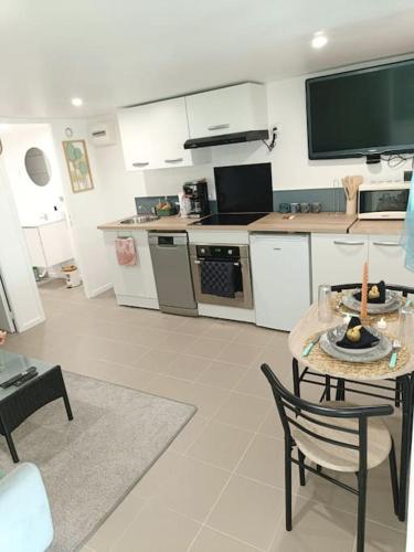 Il comprend une cuisine avec une table et une télévision. dans l'établissement l'échappée verte, à Le Mée-sur-Seine