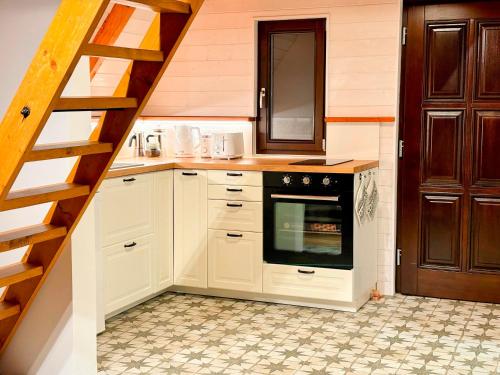 a kitchen with white cabinets and a stove at House Of Harry - horská chata in Liberec
